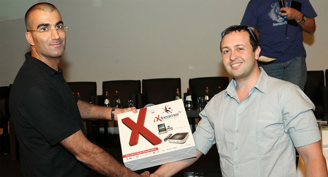 בסוף הכנס החצי שנתי הוגרלו מספר מכשירי iXtreamer. איתן עוז, מנהל המכירות של ריל קומרס, מעניק את אחד מהם לדניאל לוי מ-Tiny Love