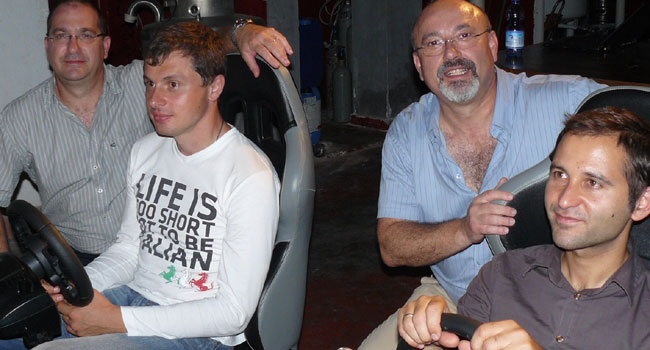 ליד הסימולטורים של פרארי: אובנס מיכאלוב, דירקטור B2B איטליה וישראל, נועם פרוימוביץ, מנכ"ל פאוור תקשורת, אלכס מוסייב, דירקטור שיתופי פעולה וחסויות בקספרסקי ואילן פרוימוביץ, מנכ"ל טכני בפאוור תקשורת