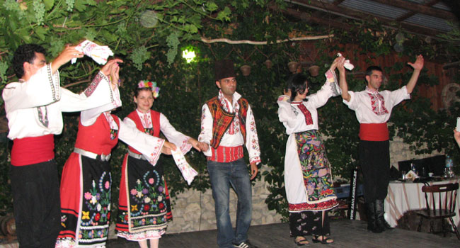 אנשי קומדע בלבוש מסורתי לצד רקדנים מקומיים