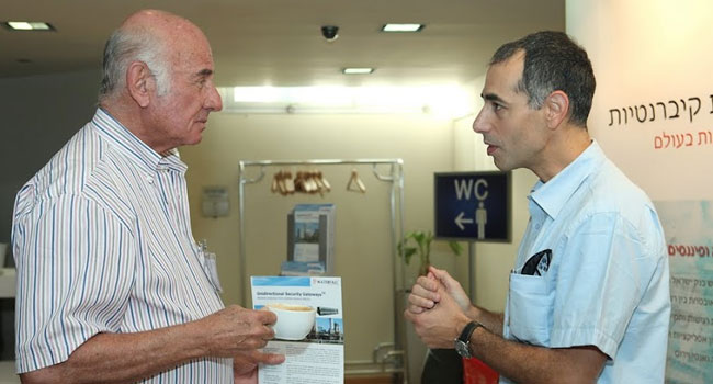 יעקב פרי, יו"ר בנק מזרחי טפחות (משמאל), משוחח בביתן של ווטרפול עם דני ברקו - ראש תחום שיווק מוצרים בחברה