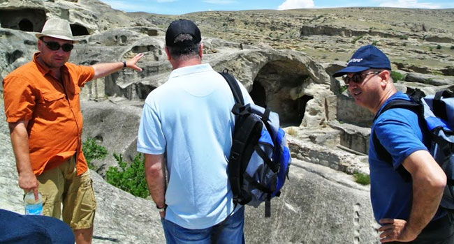 חנן אלטיף (במרכז), מאזין לסרגיי המדריך יחד עם שלמה אלה, לפני הירידה לאזור המערות העתיקות בסמוך לעיר הבירה טביליסי