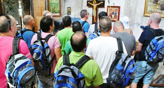 נדחקים לכניסה מעל ארץ המערות. על הגב תלוי לכל משתתף בסיור המצטיינים תיק VMware - ועל הצלב תלוי לו ישוע