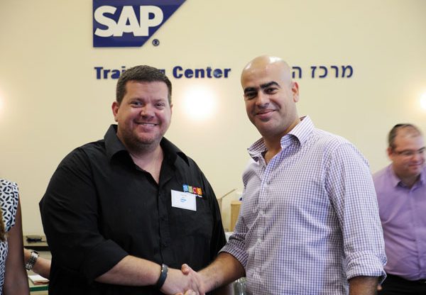 רמי מנחם - סמנכ"ל מכירות SME ומנהל השותפים העסקיים ב-SAP ישראל לוחץ יד ל- אדיר אורן, מנכ"ל BICS ישראל