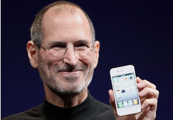סטיב ג'ובס, המייסד המיתולוגי של אפל, עם מכשיר ה-iPhone שהגיע לעולם בזכותו. צילום: מת'יו יו, מתוך ויקיפדיה