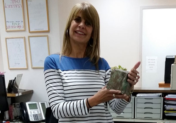 איילה בר, מנהלת אדמיניסטרציה ומתאמת הדרכות וקורסים ב-תים, ואבן מהאוסף