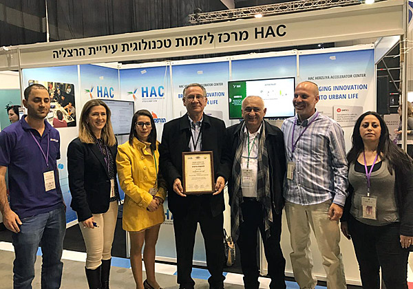 מימין: שירה לביא, מנהלת מרכז הצעירים של עיריית הרצלליה; שלומי אשכנזי, מייסד greenq; יהודה בן עזרא, מנכ"ל העירייה; משה פדלון, ראש העיר; מיה כץ סגנית וממלאת מקום ראש עיריית הרצליה; איריס ארבל גנץ, מנהלת HAC; ועומרי כהן, בוגר האקסלרטור. צילום: יח"צ HAC