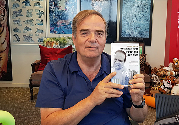 בא לבקר במאורת הנמר: גיל-עד חריש, המייסד והיו"ר הפעיל של עמותת לשובע, אוחז בספר הנמר. צילום: פלי הנמר