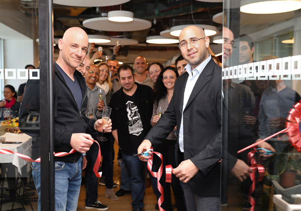מימין: עמית בן שחר - מנהל תחום בינה מלאכותית ב-LogMeIn ומנהל המרכז החדש, ויניב רזניק - סמנכ״ל מוצר לתחום חוויית לקוח בחברה, במעמד גזירת הסרט. צילום: נגה שדמי ואן דה ריפ