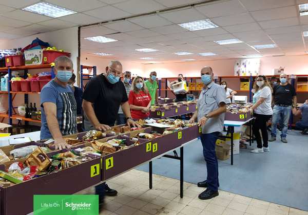 אורזים סלי מזון לקראת החג. עובדי שניידר אלקטריק ישראל. צילום: ג'רלדין רוסנטל