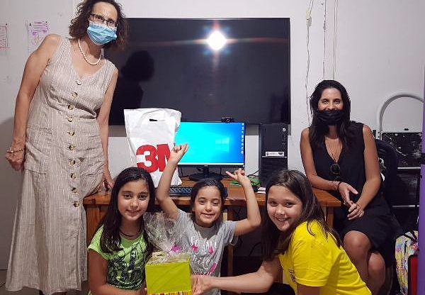 מימין לשמאל: עינת שוכר מארגון מתן-United Way, בנות המשפחה שקיבלה מחשב מלוד, ואיזבל צדיקוב, מנהלת שלוחת 3M בישראל. צילום: יח"צ