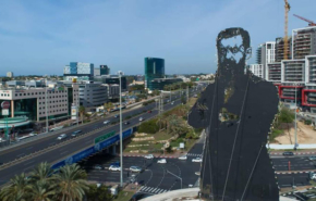 הרצל, שעל שמו קרויה הרצליה, וברקע כביש החוף (כבי 2), שמפריד בין שני חלקי העיר.